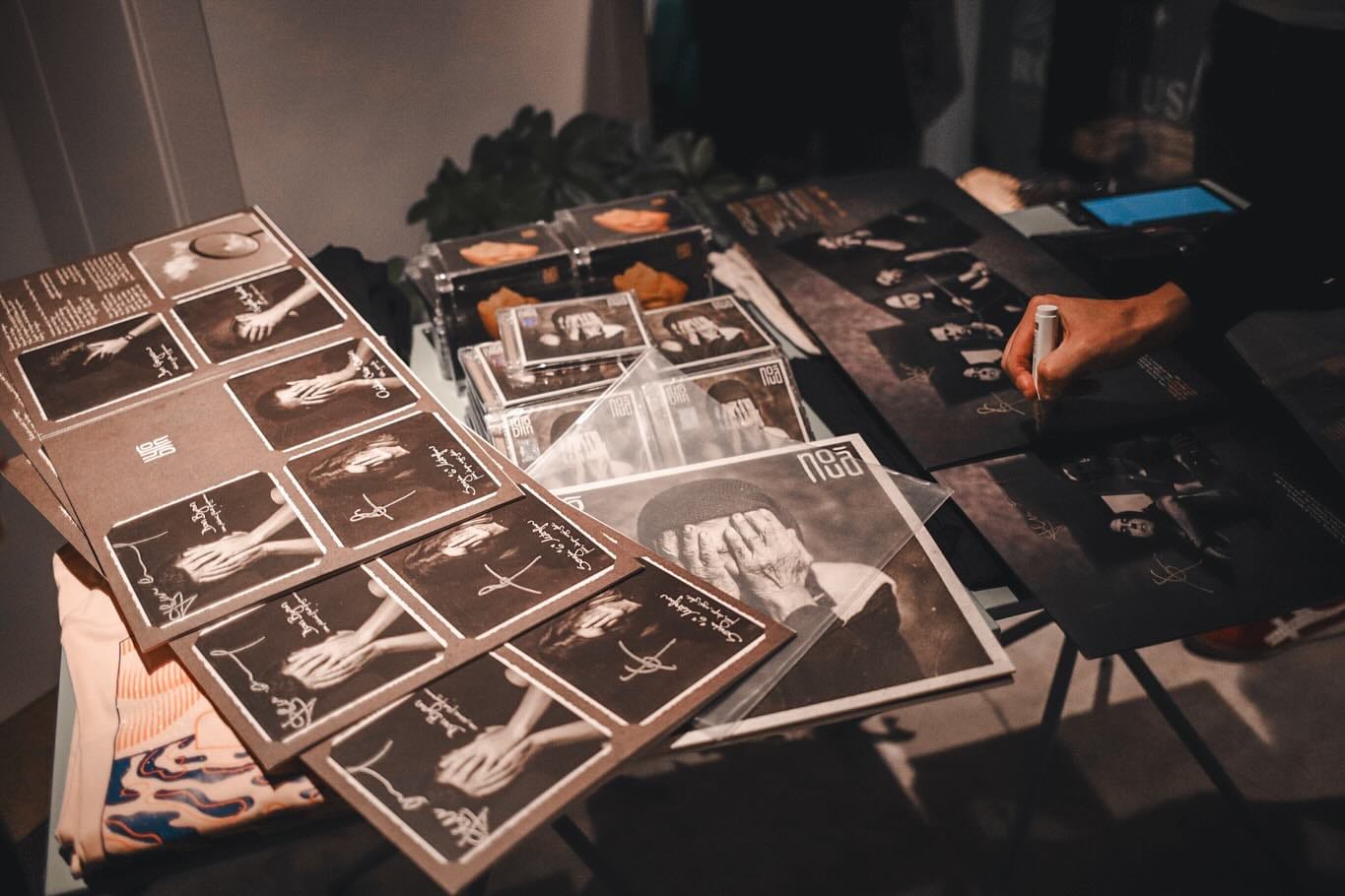 Exemplare din albumul „Nouă” al trupei byron, semnate la o lansare — vinil, CD și afișe pe masă.