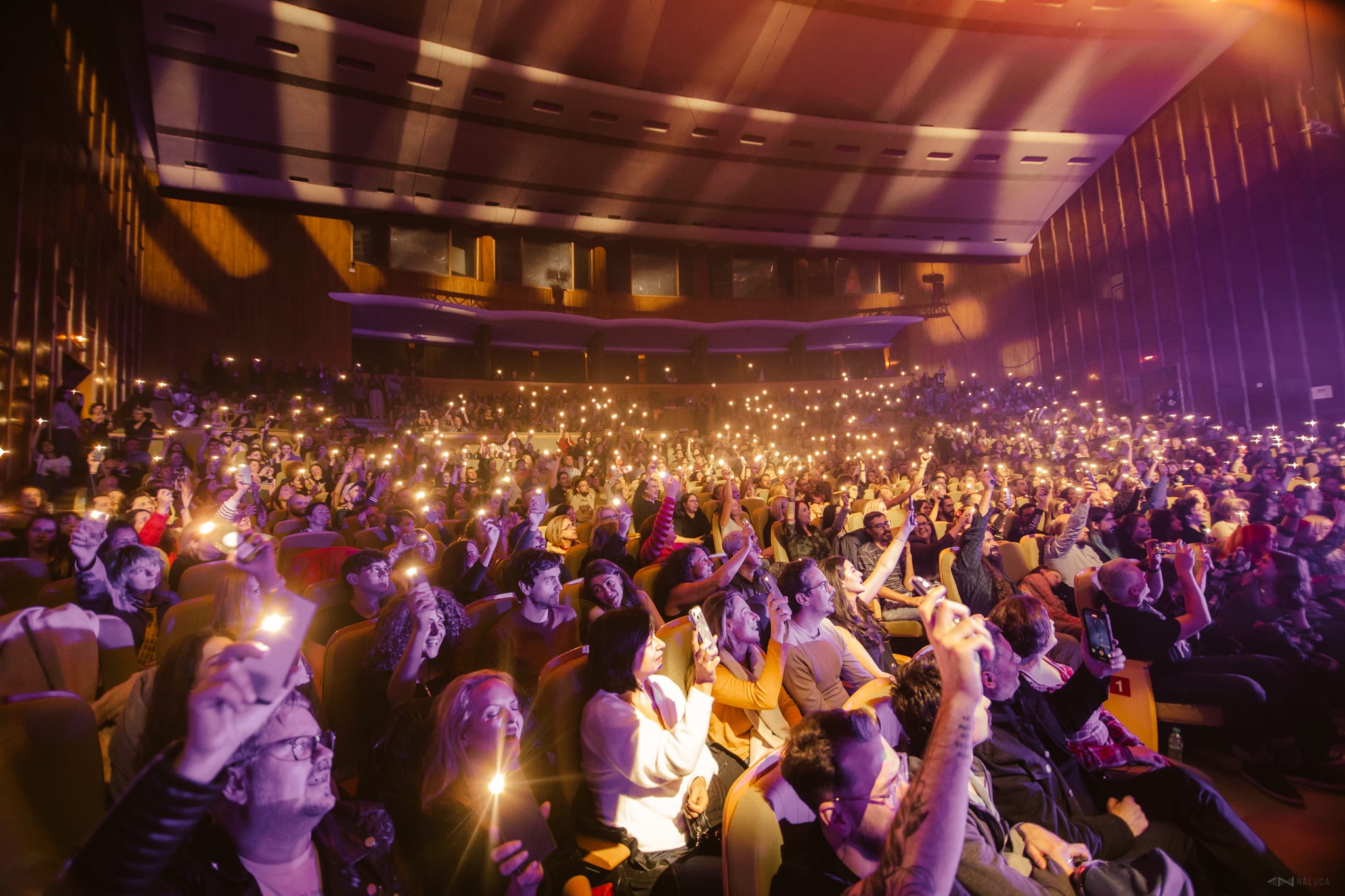Sala plină la concertul byron de la Sala Radio, luminată de telefoanele publicului.